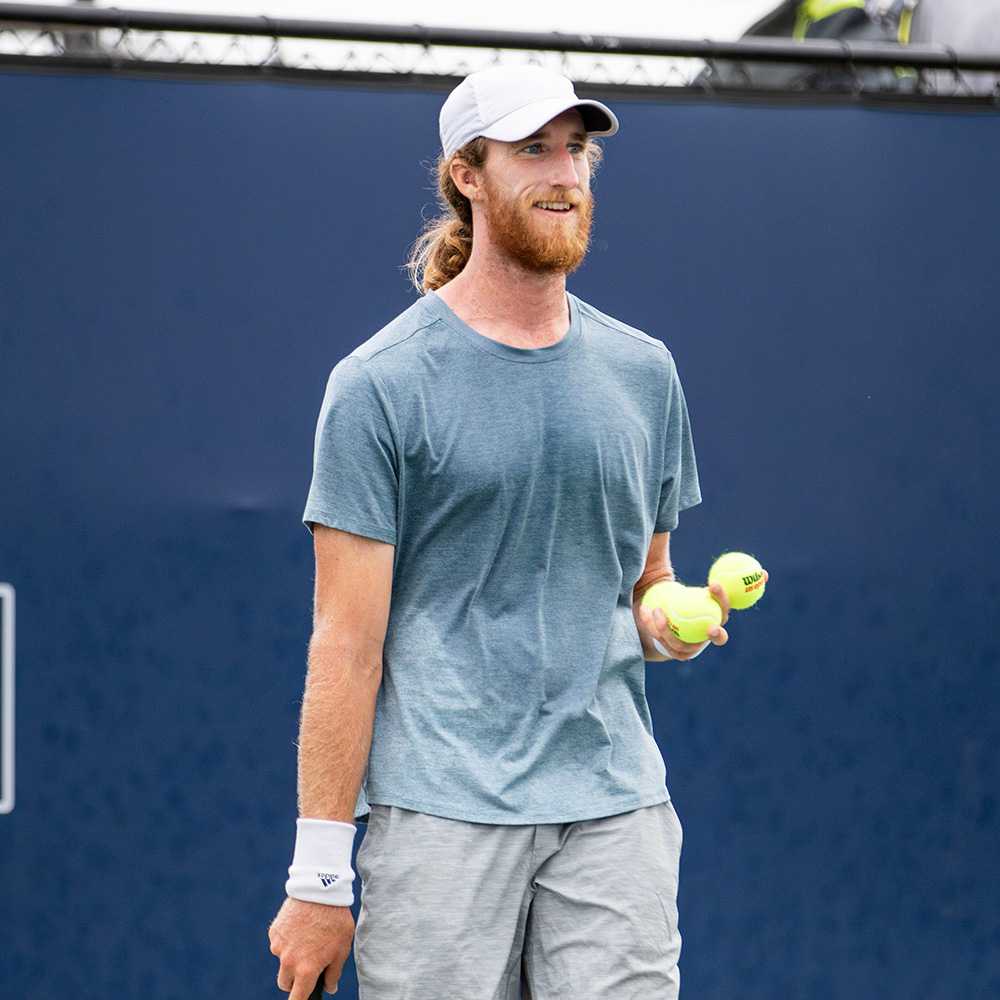Keegan Smith smiling during his first-round win at the SoCal Pro Series opener at Barnes Tennis Center.