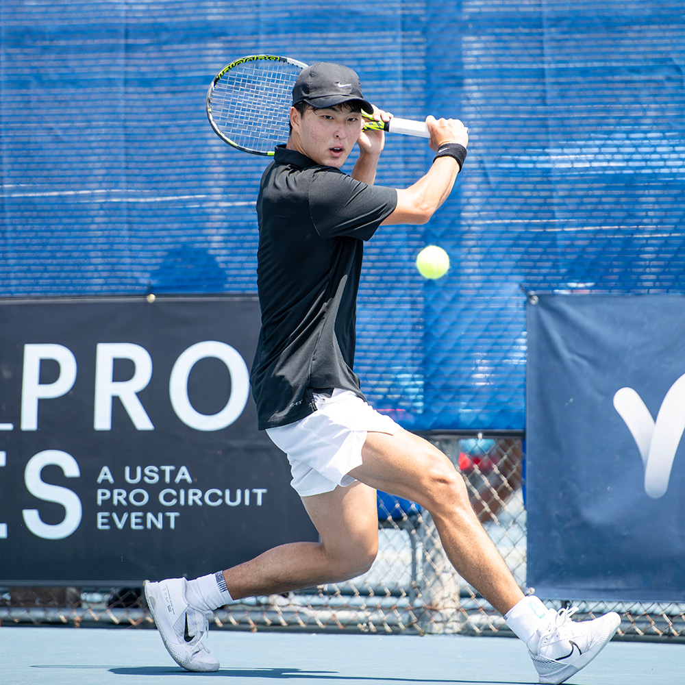 Kyle Kang hits a backhand during his SoCal Pro Series first round match at Lakewood Tennis Center