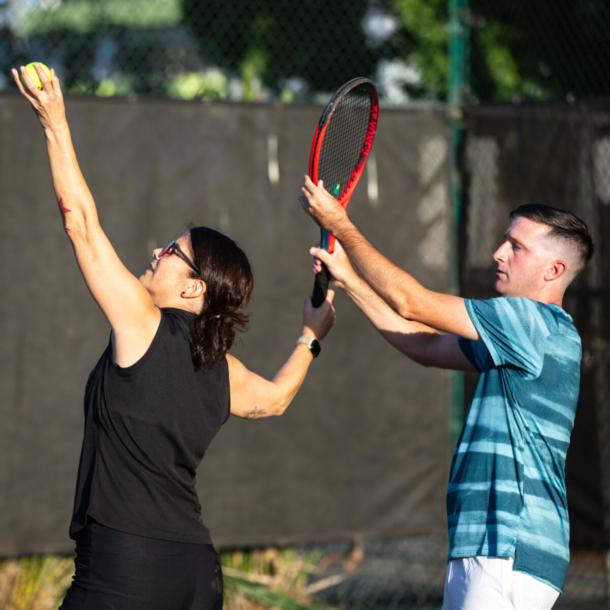 Brian “B” Bradley with a tennis student, coaching them on their serve