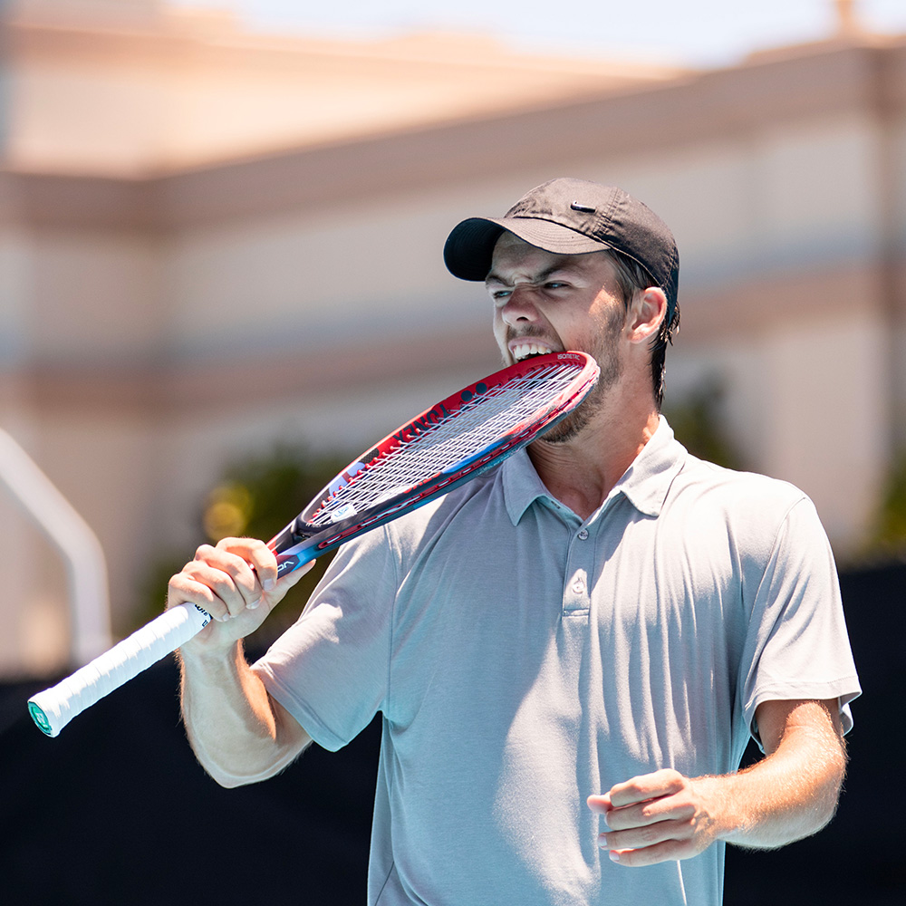 Stian Klaassen biting his tennis racquet during an intense SoCal Pro Series match