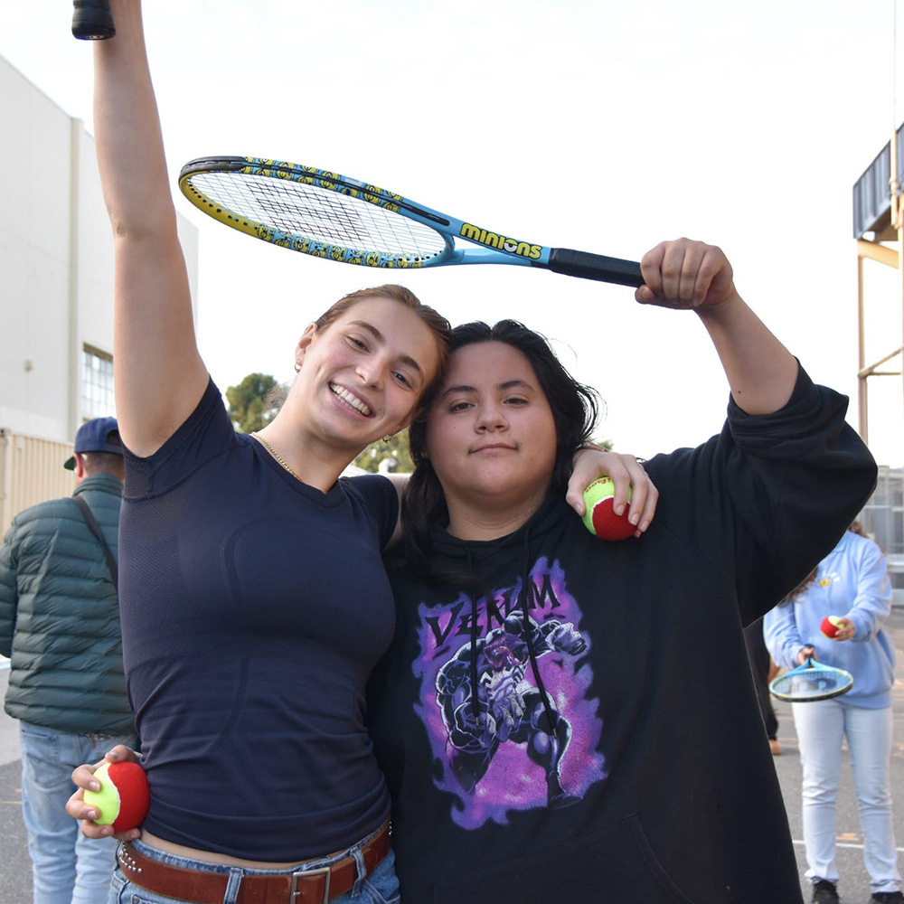 Angie Del Gaudio and a student at The Without Limits Foundation smiling while holding tennis racquets