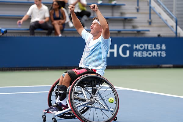 Charlie Cooper holds both of his fists in the air in excitement after winning the US Open Junior Wheelchair Championships singles title in 2024