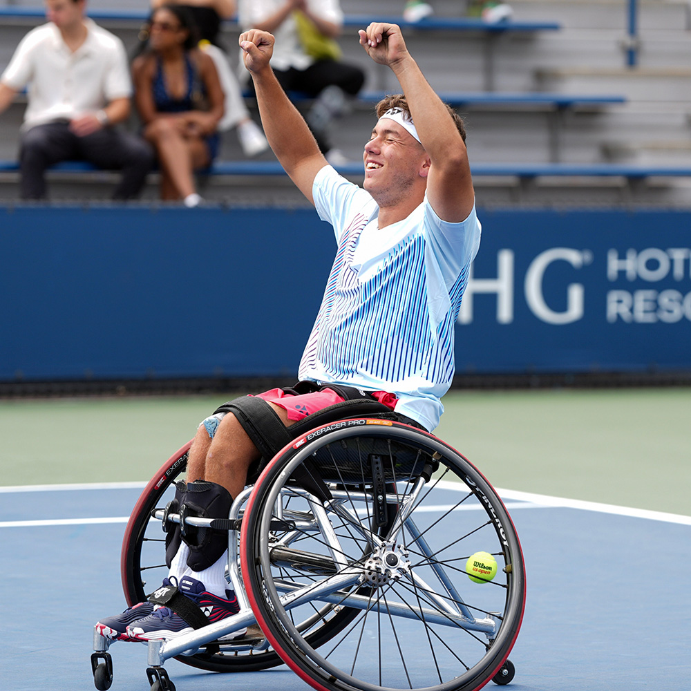 Charlie Cooper holds both of his fists in the air in excitement after winning the US Open Junior Wheelchair Championships singles title in 2024