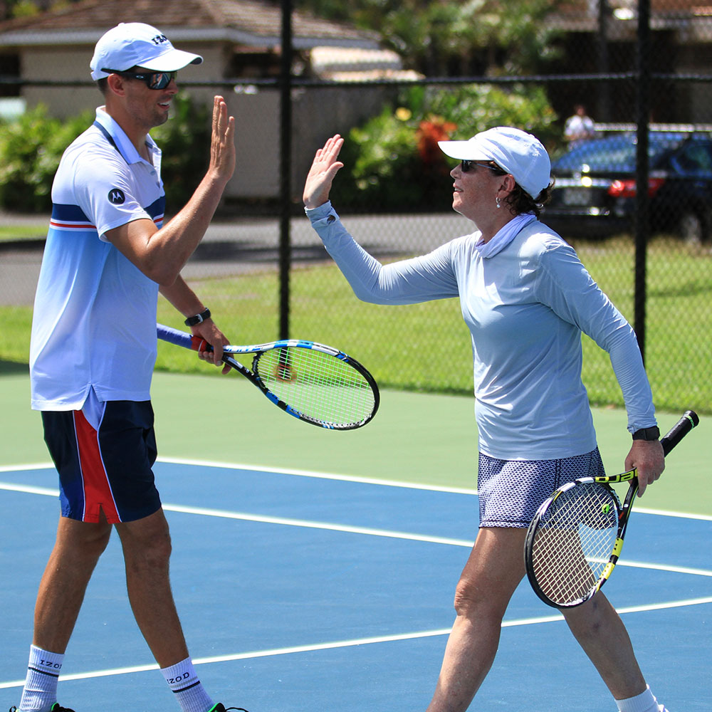 Cynthia Neiman and Mike Bryan high fiving while playing tennis