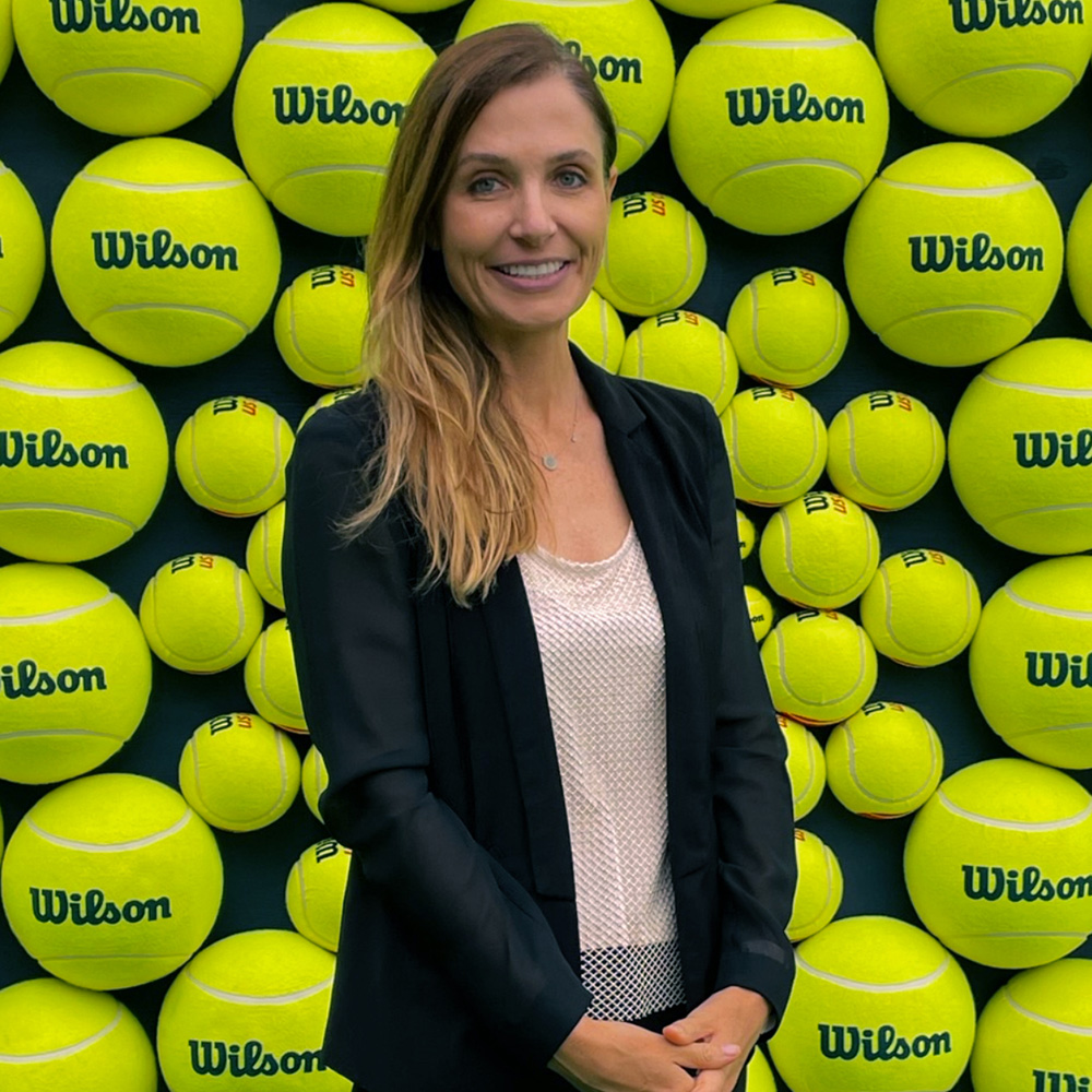 Gailor Large posing in front of a Wilson tennis ball wall