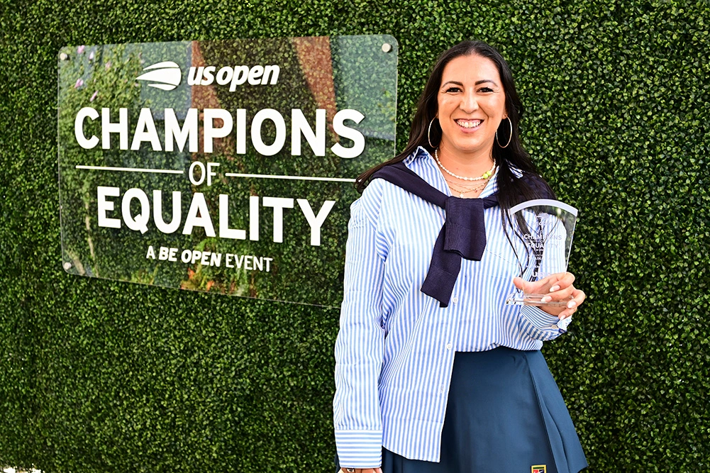Shaina Zaidi of Tume Tennis holds her Champions of Equality section award trophy in front of the event sign at the 2025 US Open in Flushing, New York.