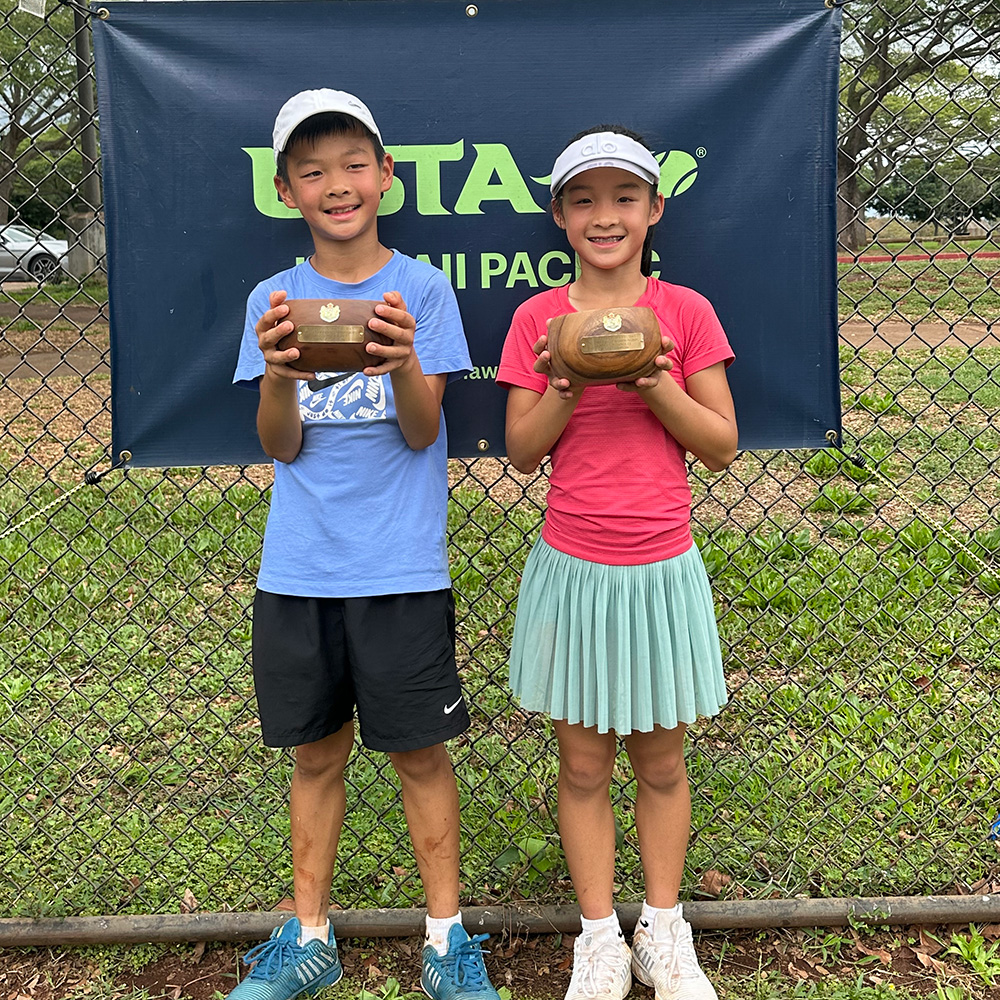 William and Lindy Zhou holding trophies at a tennis tournament