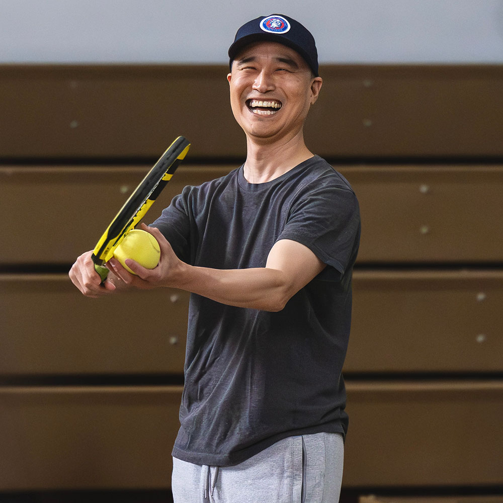 Eugene Kim from La Crescenta laughing on court during Blind and Low Vision Tennis action at the USTA Southern California adaptive tennis event.