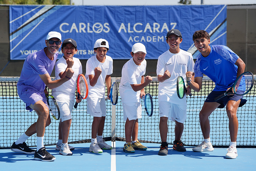Group of coaches and tennis players fist pumping at the Carlos Alcaraz Academy Camps in Southern California