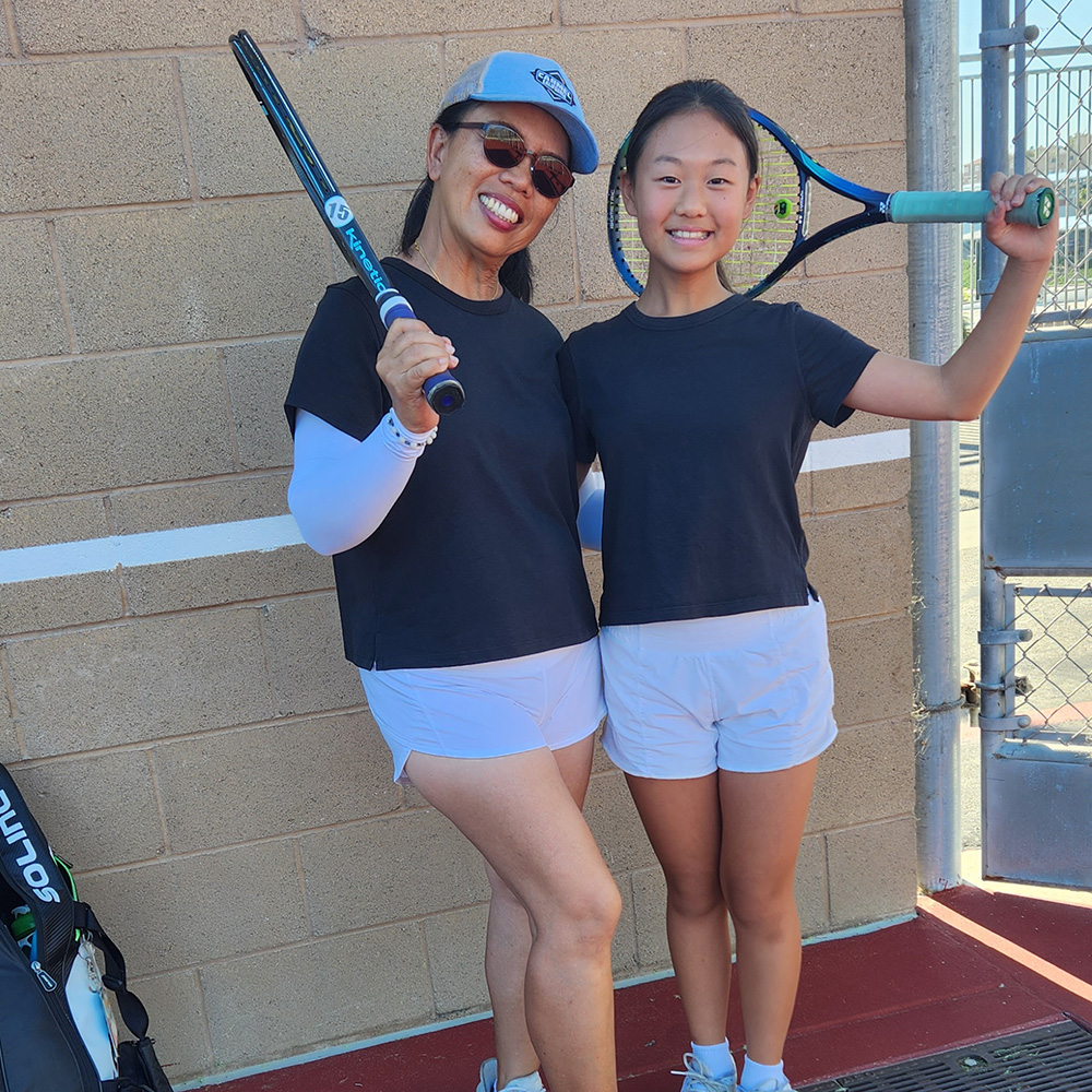 Jeanette Lee and a junior tennis player holding tennis racquets