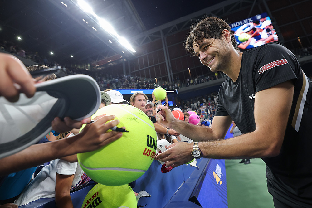Taylor Fritz smiles as he signs an autograph for fans during a men's singles match at the 2025 US Open on Sunday, Aug. 31, 2025 in Flushing, NY.